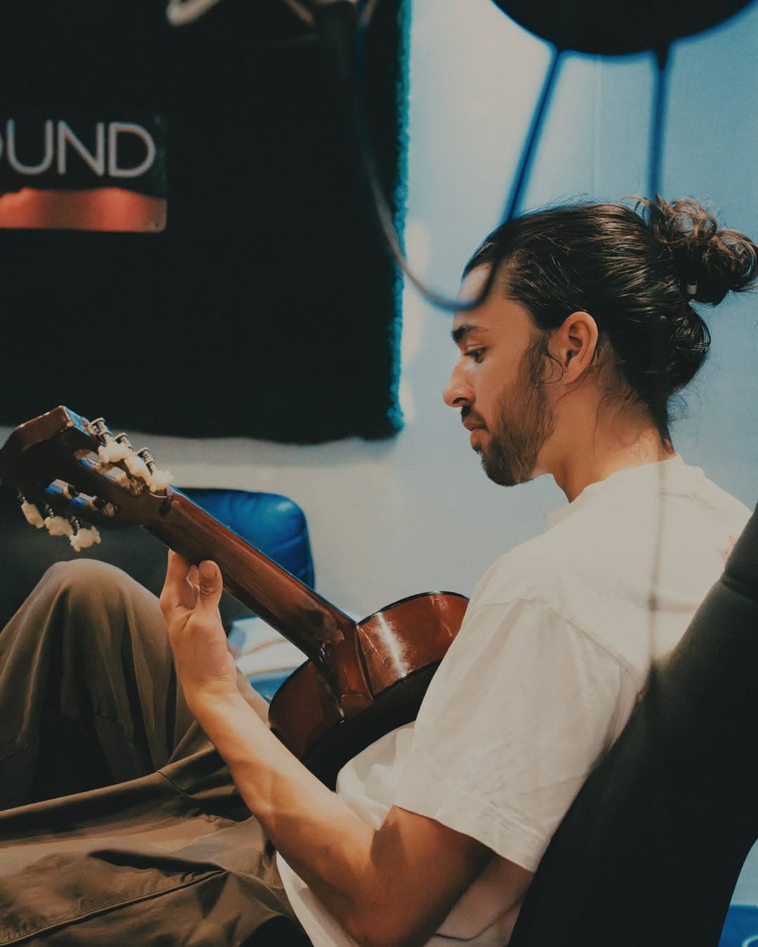 Artist playing acoustic guitar in the Uniq Sound booth during the KENEKT camp